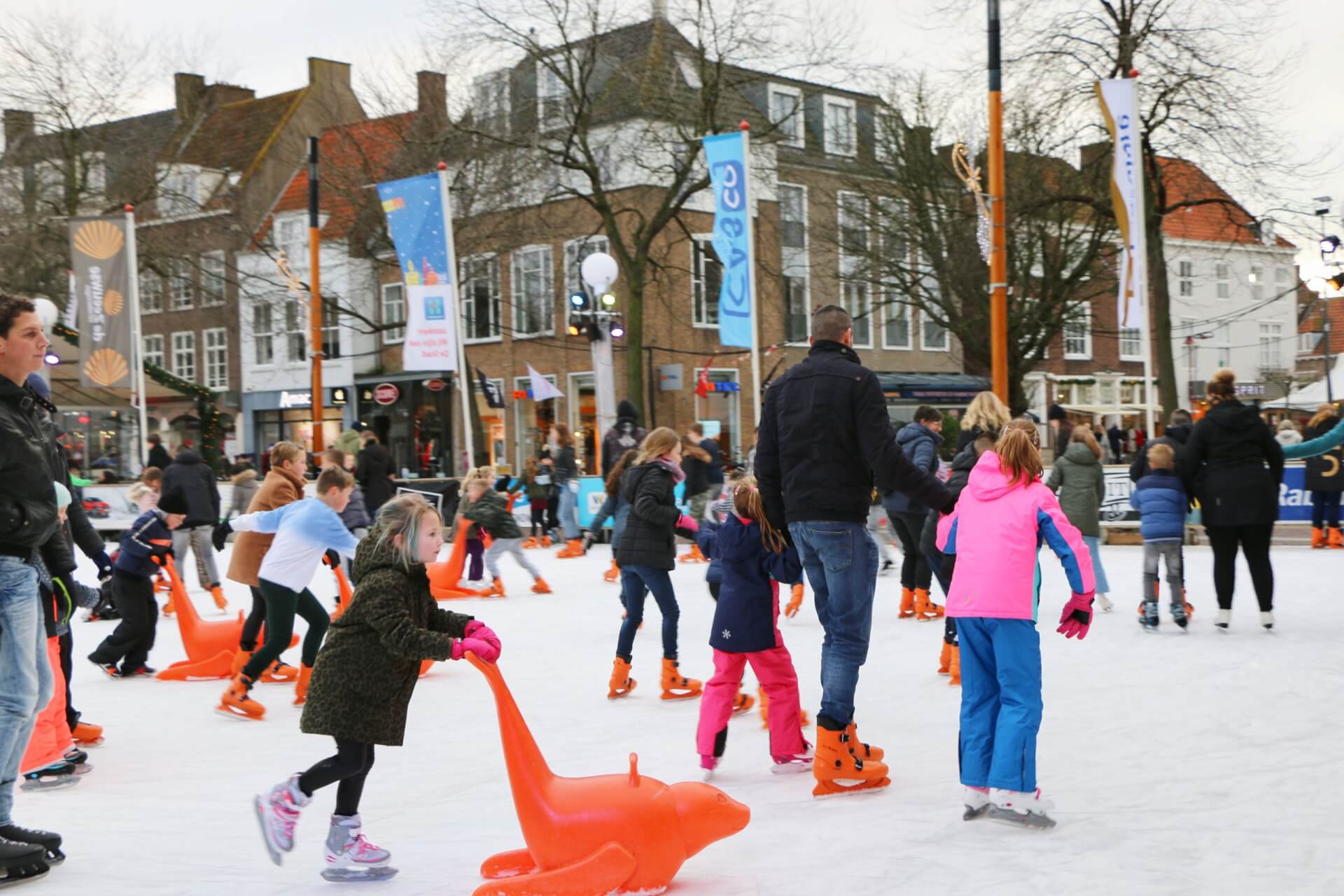 Bezoekers glijden op rubberbanden over de ijsbaan in Middelburg